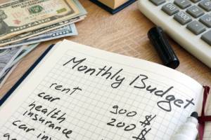 Note pad with monthly budget calculations and money. Personal finance for beginners.